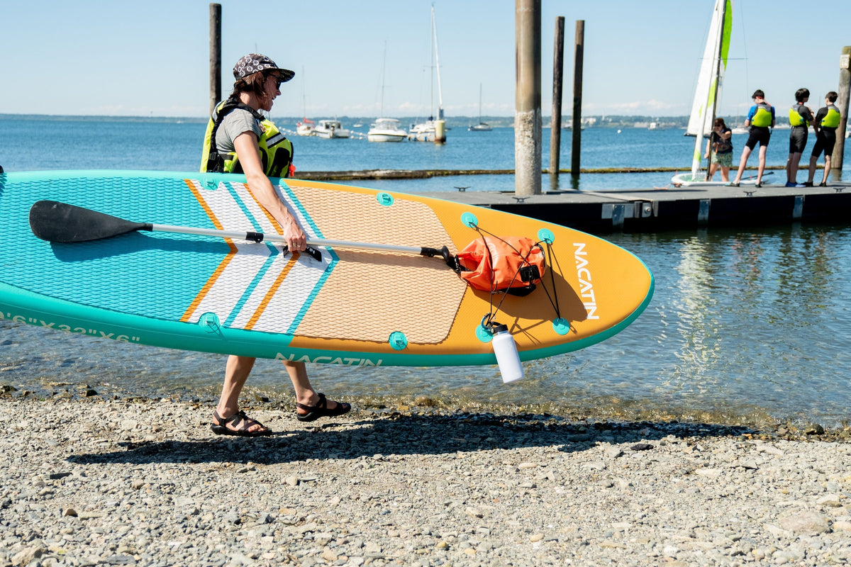 Woman carrying SUP to water